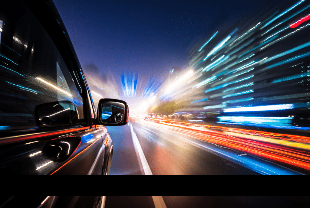 A vibrant car photography capture showcasing motion with colorful light trails at night